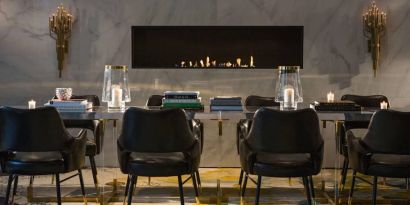 The Allegro Royal Sonesta Hotel Chicago Loop’s lobby lounge includes a table, comfortable seating, and a fireplace.