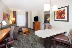 Sonesta ES Suites Atlanta - Perimeter Center double bed guest room, with living area that has a desk and chair, sofa, coffee tables, window, and TV.