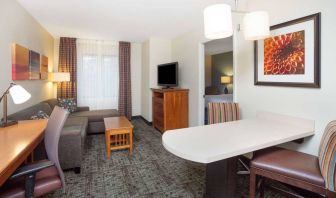 Sonesta ES Suites Atlanta - Perimeter Center double bed guest room, with living area that has a desk and chair, sofa, coffee tables, window, and TV.