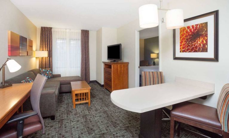 Sonesta ES Suites Atlanta - Perimeter Center double bed guest room, with living area that has a desk and chair, sofa, coffee tables, window, and TV.