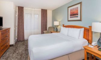 Sonesta ES Suites Atlanta - Perimeter Center double bed guest room, featuring TV, armchair, and window.