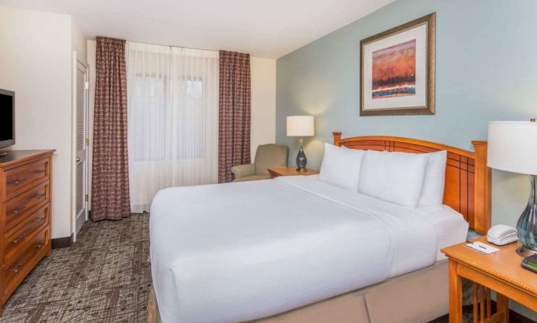 Sonesta ES Suites Atlanta - Perimeter Center double bed guest room, featuring TV, armchair, and window.