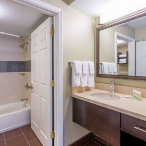 Guest bathroom in Sonesta ES Suites Atlanta - Perimeter Center, with shower and bath, sink and mirror.