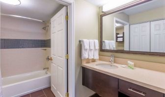 Guest bathroom in Sonesta ES Suites Atlanta - Perimeter Center, with shower and bath, sink and mirror.