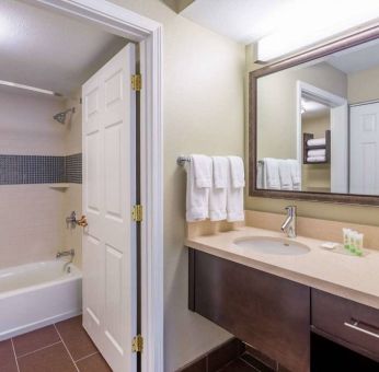 Guest bathroom in Sonesta ES Suites Atlanta - Perimeter Center, with shower and bath, sink and mirror.