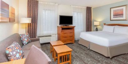 Double bed guest room in Sonesta ES Suites Atlanta - Perimeter Center, including coffee tables, windows, TV, and sofa.