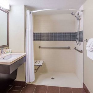 Guest bathroom in Sonesta ES Suites Atlanta Alpharetta Avalon featuring shower with curtain, mirror, and sink.