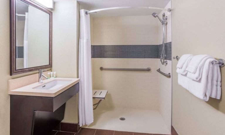 Guest bathroom in Sonesta ES Suites Atlanta Alpharetta Avalon featuring shower with curtain, mirror, and sink.