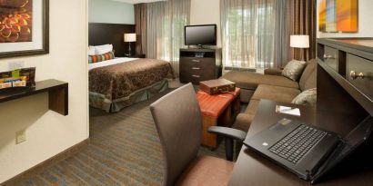 Double bed guest room in Sonesta ES Suites Atlanta Alpharetta Avalon, with sofa, TV, windows, and a workspace desk and chair.