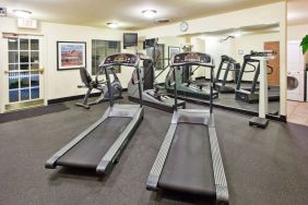 Sonesta ES Suites Atlanta Alpharetta Avalon’s fitness center is equipped with a range of exercise machinery and a wall-mounted television.