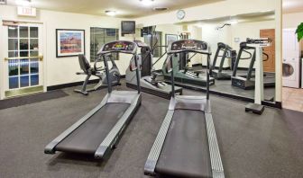 Sonesta ES Suites Atlanta Alpharetta Avalon’s fitness center is equipped with a range of exercise machinery and a wall-mounted television.