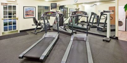 Sonesta ES Suites Atlanta Alpharetta Avalon’s fitness center is equipped with a range of exercise machinery and a wall-mounted television.