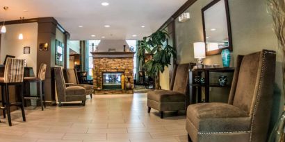 Sonesta ES Suites Atlanta Alpharetta Avalon’s common area lounge is furnished with comfortable seating, potted plants, and a fireplace.