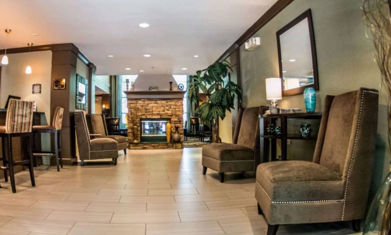 Sonesta ES Suites Atlanta Alpharetta Avalon’s common area lounge is furnished with comfortable seating, potted plants, and a fireplace.