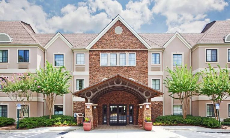 The hotel’s exterior has a brickwork entranceway which is under cover, as are the two nearby benches, with pleasant greenery flanking the front door.