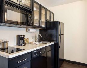 Sonesta Simply Suites Detroit Troy guest room kitchen, equipped with microwave, hob, and fridge-freezer.