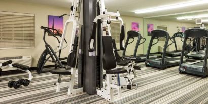 Sonesta Simply Suites Detroit Troy’s fitness center includes free weights, a mirrored wall, and various types of exercise machine.