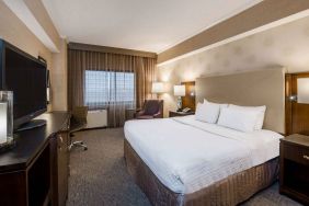 Double bed guest room in Sonesta White Plains Downtown, featuring window, armchair, and TV.