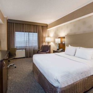 Double bed guest room in Sonesta White Plains Downtown, featuring window, armchair, and TV.