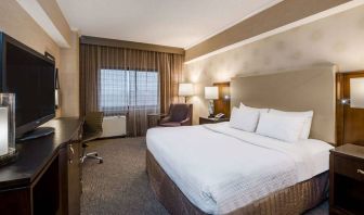 Double bed guest room in Sonesta White Plains Downtown, featuring window, armchair, and TV.