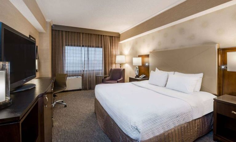 Double bed guest room in Sonesta White Plains Downtown, featuring window, armchair, and TV.