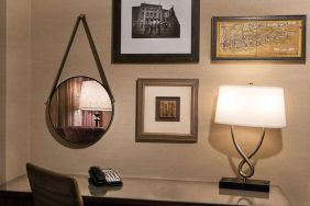 Sonesta White Plains Downtown guest room workspace, including chair, desk, lamp, telephone, and art on the wall.