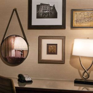 Sonesta White Plains Downtown guest room workspace, including chair, desk, lamp, telephone, and art on the wall.