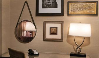 Sonesta White Plains Downtown guest room workspace, including chair, desk, lamp, telephone, and art on the wall.