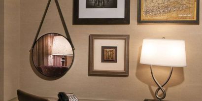 Sonesta White Plains Downtown guest room workspace, including chair, desk, lamp, telephone, and art on the wall.