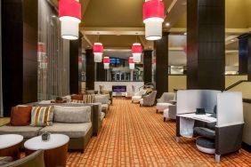 Sonesta White Plains Downtown’s lobby lounge is furnished with sofa and armchair seating, coffee tables, and a fireplace.