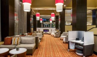 Sonesta White Plains Downtown’s lobby lounge is furnished with sofa and armchair seating, coffee tables, and a fireplace.