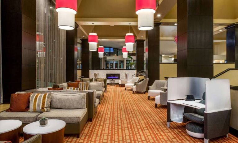 Sonesta White Plains Downtown’s lobby lounge is furnished with sofa and armchair seating, coffee tables, and a fireplace.