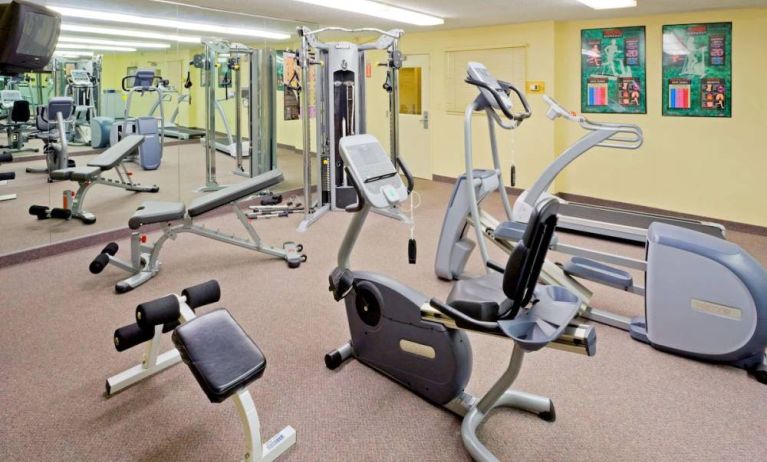 Sonesta Simply Suites Parsippany Morris Plains’ fitness center is equipped with assorted exercise machines, a mirrored wall, and a TV.