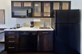 Guest room kitchen in Sonesta Simply Suites Oklahoma City Airport, furnished with microwave, hob, and fridge-freezer.