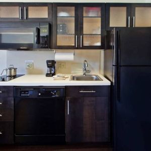 Guest room kitchen in Sonesta Simply Suites Oklahoma City Airport, furnished with microwave, hob, and fridge-freezer.