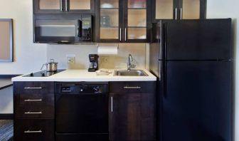 Guest room kitchen in Sonesta Simply Suites Oklahoma City Airport, furnished with microwave, hob, and fridge-freezer.