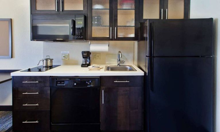 Guest room kitchen in Sonesta Simply Suites Oklahoma City Airport, furnished with microwave, hob, and fridge-freezer.