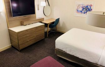 Double bed guest room in Sonesta Columbus Downtown, with workspace desk and chair plus a widescreen television.