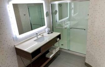 Guest bathroom in Sonesta Columbus Downtown, with shower, sink, and mirror.