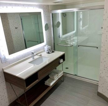 Guest bathroom in Sonesta Columbus Downtown, with shower, sink, and mirror.