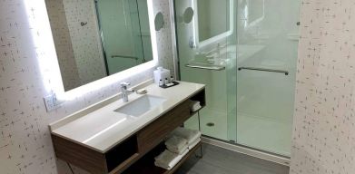 Guest bathroom in Sonesta Columbus Downtown, with shower, sink, and mirror.