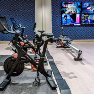 The fitness center in Sonesta Columbus Downtown has an assortment of exercise machines and multiple widescreen TVs on the wall.