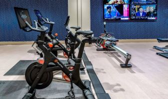 The fitness center in Sonesta Columbus Downtown has an assortment of exercise machines and multiple widescreen TVs on the wall.