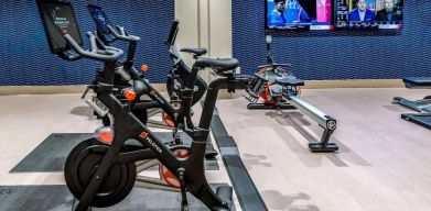 The fitness center in Sonesta Columbus Downtown has an assortment of exercise machines and multiple widescreen TVs on the wall.