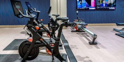 The fitness center in Sonesta Columbus Downtown has an assortment of exercise machines and multiple widescreen TVs on the wall.