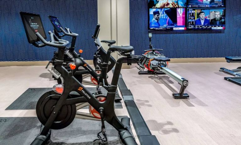 The fitness center in Sonesta Columbus Downtown has an assortment of exercise machines and multiple widescreen TVs on the wall.