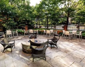 Sonesta Columbus Downtown’s patio features a fire pit that is surrounded by chairs with more tables and chairs nearby.