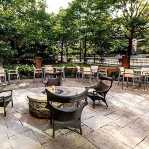 Sonesta Columbus Downtown’s patio features a fire pit that is surrounded by chairs with more tables and chairs nearby.