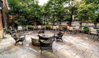 Sonesta Columbus Downtown’s patio features a fire pit that is surrounded by chairs with more tables and chairs nearby.