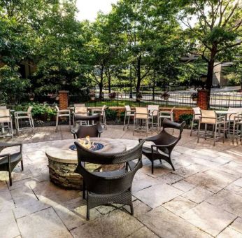 Sonesta Columbus Downtown’s patio features a fire pit that is surrounded by chairs with more tables and chairs nearby.